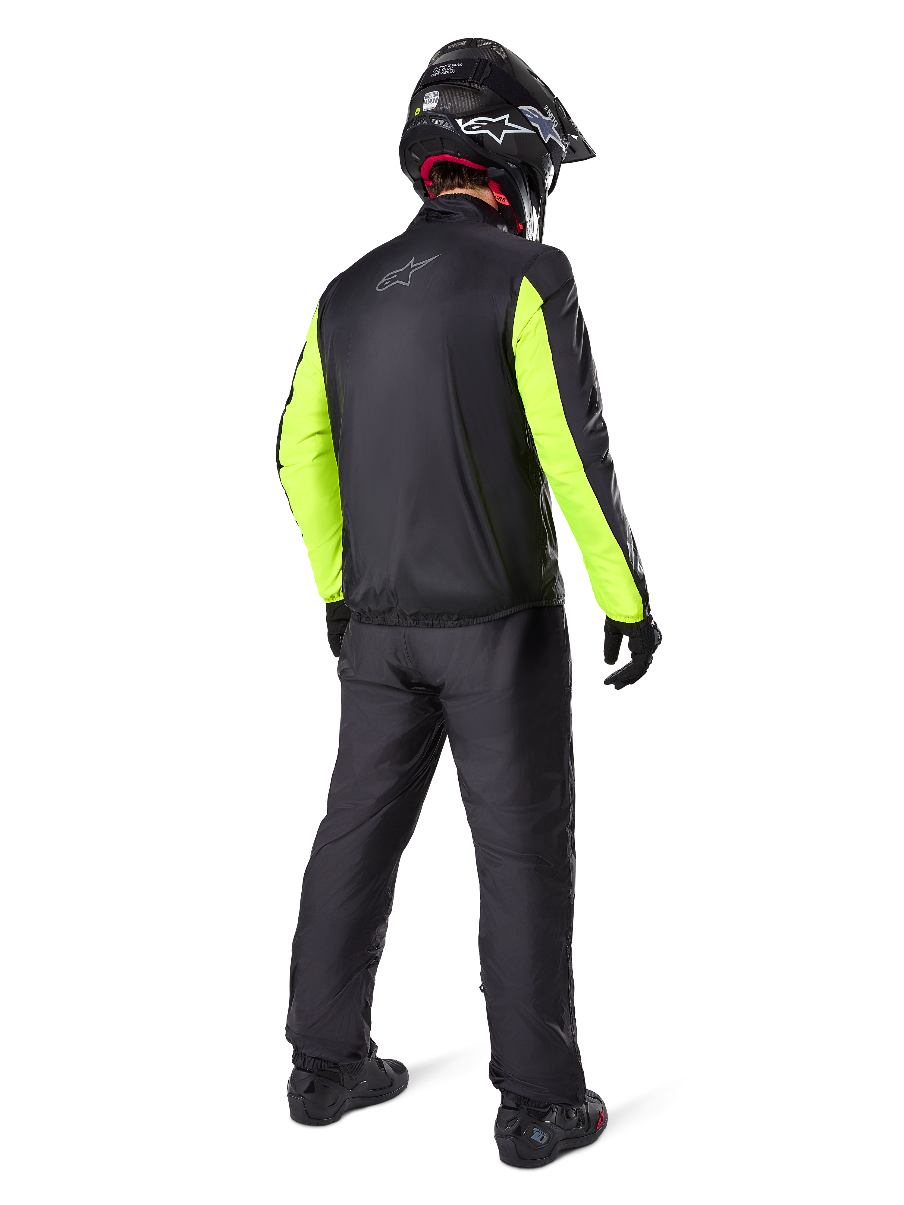Motorcycle rider seen from the back wearing the Alpinestars Bogotá Pro Drystar® Jacket, Black with bright Yellow Fluo sleeves, matching black pants and helmet, technical all-season adventure gear