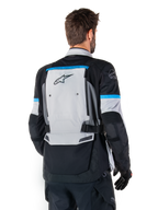Alpinestars Bogota' Pro Drystar® Jacke, Adventure-Motorradjacke, Ice Gray, Schwarz und Cyan, Rückansicht mit Fokus auf dem großen grauen Rückenpanel mit Tech Touring-Branding, cyanfarbene Akzente an den Ärmeln, strapazierfähige Textilkonstruktion