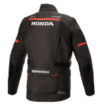 Alpinestars Honda Andes V3 Drystar® jas, zwart, achteraanzicht met witte Honda en Alpinestars logo's, rode accentstrepen op de schouders en mouwen, adventure touring motorjas met reflecterende details en een grote utility-zak aan de achterzijde.
