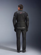 Alpinestars Andes Air Drystar® jas en broek, zwarte motor touringoutfit, achteraanzicht van de rijder, voorzien van mesh-panelen, rood sterlogo en reflecterende Alpinestars-branding op de jas, gedragen met zwarte handschoenen en laarzen.