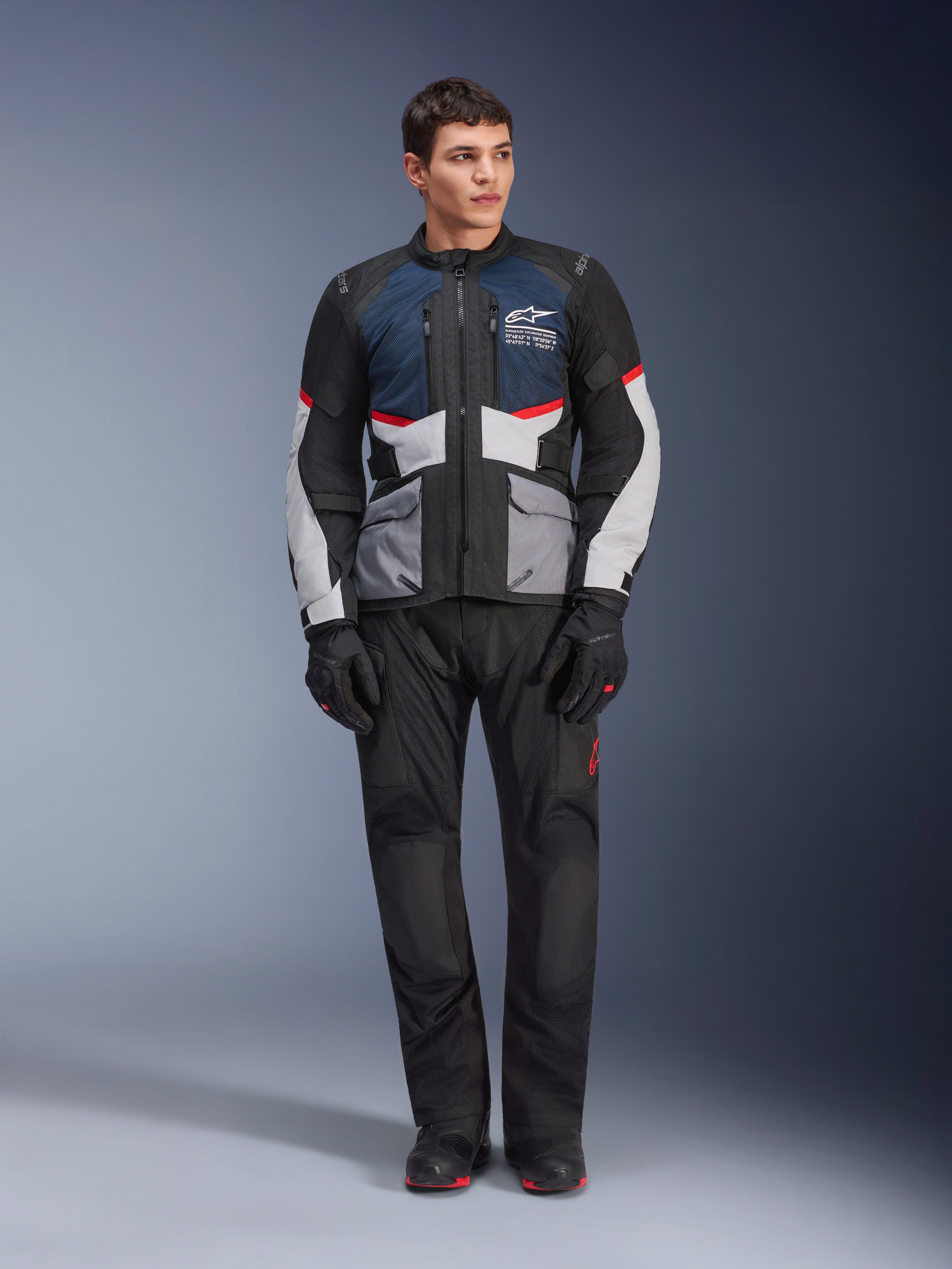 Alpinestars Andes Air Drystar® Jacke, Motorrad-Tourenjacke, Deep Blue Black und Ice Gray, getragen mit passender schwarzer Adventure-Hose und Handschuhen, mit Mesh-Einsätzen für Luftzirkulation und einem technischen Multi-Taschen-Design.