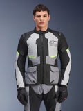Männlicher Fahrer trägt die Alpinestars Andes Air Drystar® Jacke in Ice Gray, Dunkelgrau und Schwarz, mit neongelben Akzenten und Mesh-Belüftungseinsätzen, kombiniert mit passender Motorradhose und Handschuhen, Adventure-Touring-Ausrüstung