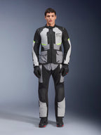 Alpinestars Andes Air Drystar® Hose, Adventure-Touring-Motorradhose, Eisgrau und Schwarz mit neongelben Akzenten, Ganzkörperansicht eines Modells mit passender Jacke und Handschuhen, Textildesign mit Mesh-Belüftungseinsätzen