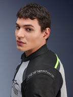 Nahaufnahme eines Models in der Alpinestars Andes Air Drystar® Jacke in Ice Gray, Dark Gray und Schwarz, mit neongelben Akzenten und Mesh-Einsätzen, sichtbares Alpinestars-Branding auf der Schulter.