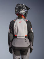 Veste Alpinestars Stella Andes V4 Drystar®, veste de moto aventure pour femme, grise et noire avec corail fluo, vue de dos.