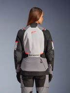 Veste Alpinestars Stella Andes V4 Drystar®, veste de moto aventure pour femme, grise et corail, vue de dos, membrane imperméable et protection Nucleon Flex Plus.