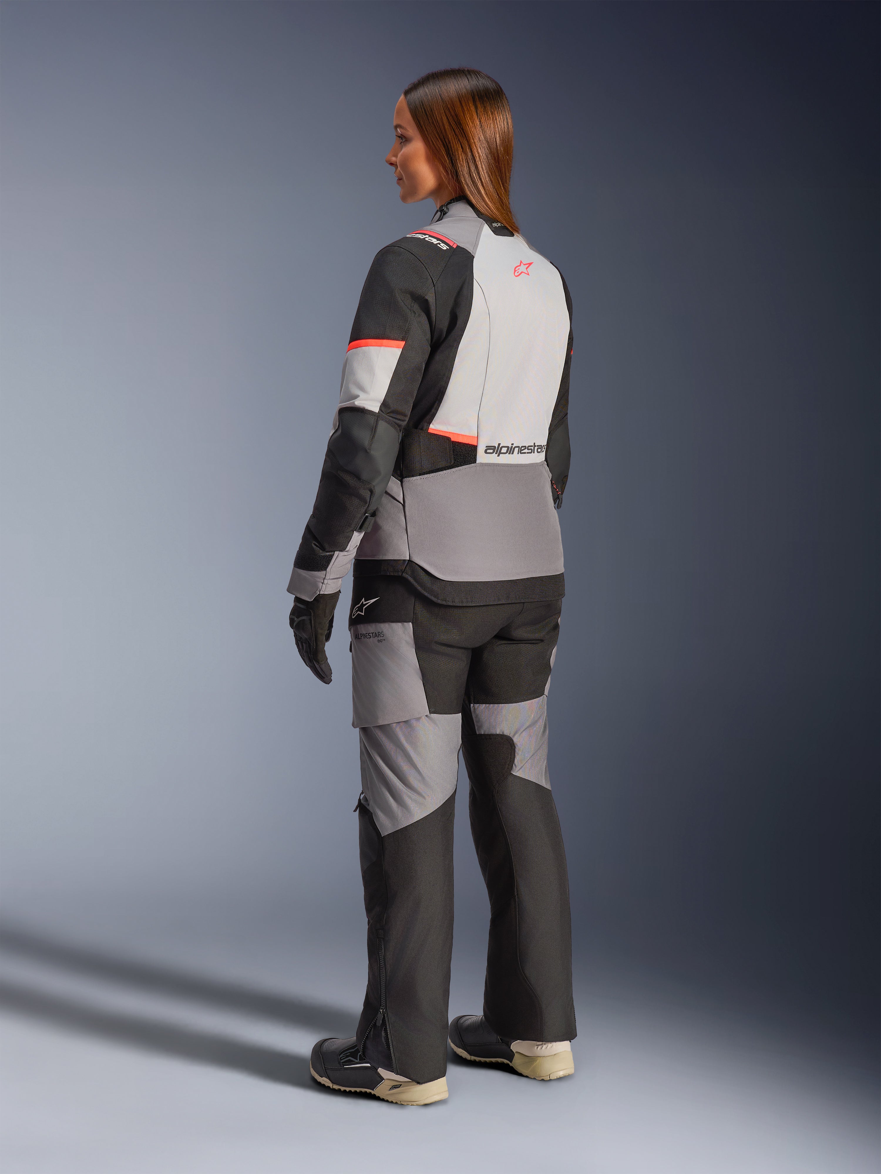Veste Stella Andes V4 Drystar d'Alpinestars, veste de moto aventure pour femme, grise et noire avec détails corail, vue de dos, imperméable.