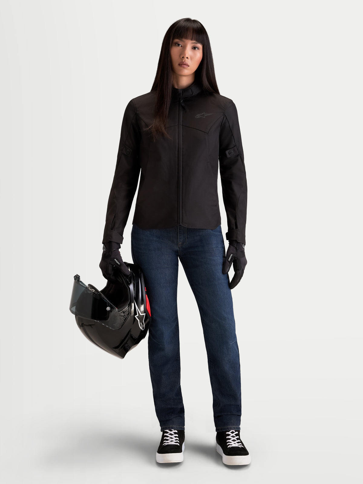 Alpinestars Stella C-1 Waterproof jas, urban motorjas voor dames in zwart, voorkant gedragen door model die een helm vasthoudt