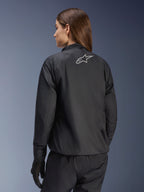 Veste Alpinestars Stella Andes Air Drystar®, veste de moto pour femme, noire, vue arrière montrant le logo étoile argenté, associée à un pantalon et des gants noirs, équipement de touring imperméable léger
