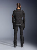Pantalon Alpinestars Stella Andes Air Drystar®, pantalon de moto pour femme, noir, vue de dos porté avec une veste en maille assortie présentant des accents rouges, mettant en valeur les panneaux de ventilation en maille et le logo réfléchissant dans le bas du dos, conçu pour l'aventure et le touring routier.
