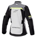 Alpinestars Stella Bogotá Pro Drystar® Damenjacke, Rückansicht, Eisgrau und Dunkelgrau mit neongelben Akzenten, großes Logo auf dem Rücken, „Tech Touring“-Schriftzug, vertikale Belüftungsreißverschlüsse, verstärkte Akkordeon-Einsätze an den Ellbogen.