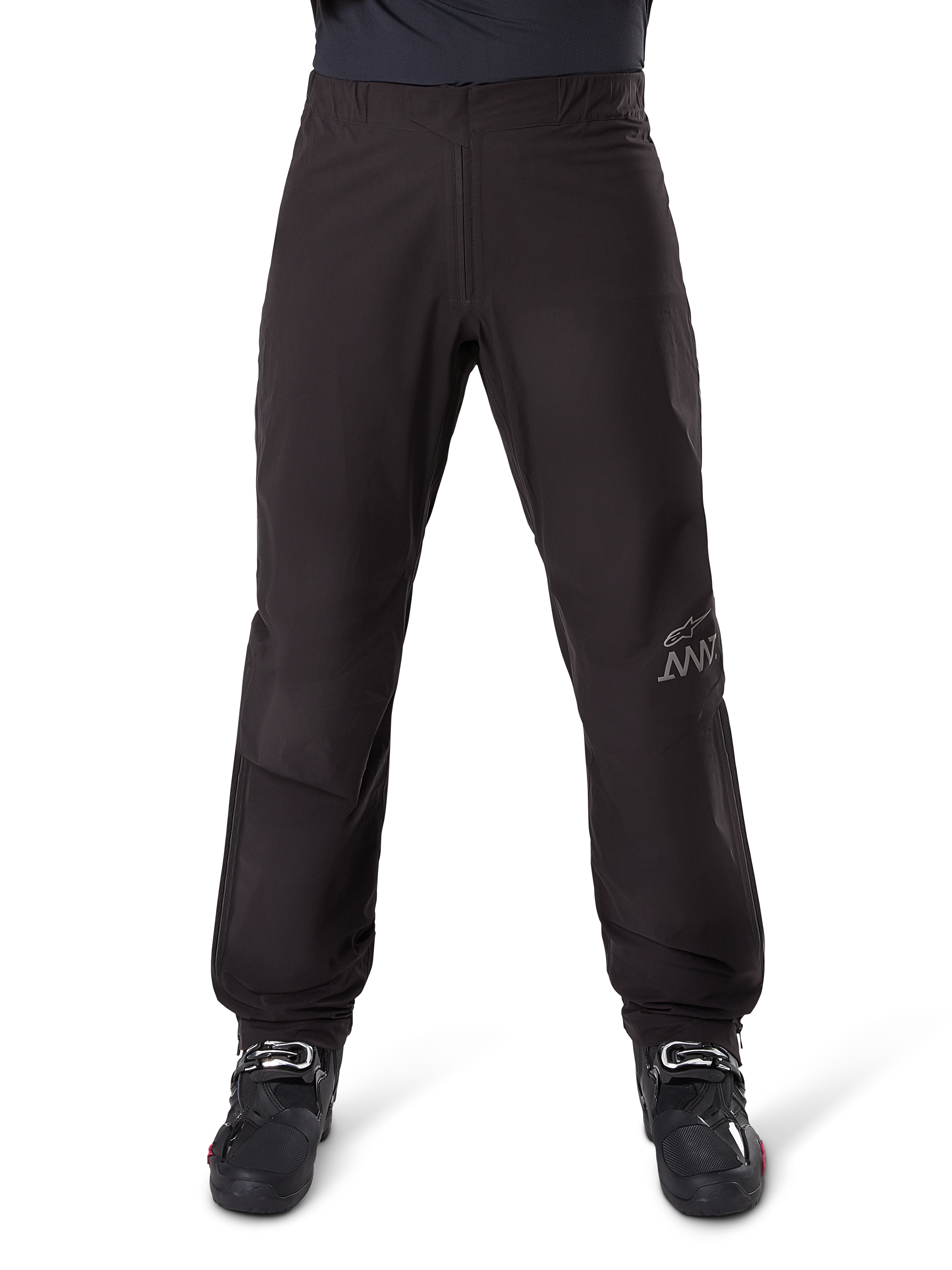 Alpinestars Amt 8 Stretch Drystar® XF Pant Liner, zwarte water- en winddichte binnenbroek, voorzien van AMT-branding op de broekspijp, gedragen met zwarte motorlaarzen, gestroomlijnd en ergonomisch adventure touring-ontwerp