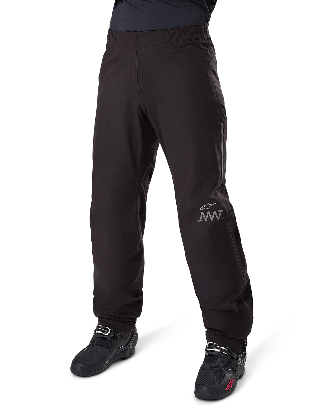 Alpinestars Amt 8 Stretch Drystar® XF Pant Liner, waterdichte motorbroek, zwart, voorzien van een grijs AMT-logo op het linkeronderbeen, gedragen met zwarte motorlaarzen, functioneel ontwerp voor adventure rijden onder alle weersomstandigheden