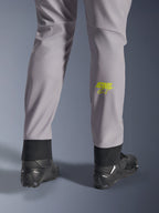 Alpinestars Aeroshell Hose, Mittelgrau mit Yellow Fluo Astars-Logo auf der Wade, Rückansicht mit schwarzen Motorradschuhen, elastischer unterer Saum und moderne, schmal zulaufende Silhouette