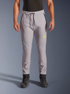 Alpinestars Aeroshell Hose, Mittelgrau und Gelb Fluo, Crossover-Softshell-Motorradhose, schwarzer Kordelzug, eng anliegende Bündchen, gelbes Logo am linken Oberschenkel, vorgeformte Knie, sportliche Jogger-Silhouette