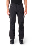 Alpinestars Hyde XT Drystar Hose, schwarze Adventure-Touring-Hose, getragen von einem Fahrer mit schwarzen Stiefeln, graue Logos auf den Oberschenkeln, integrierter Gürtel, verstärkte Kniepaneele, wasserdichte Textilkonstruktion.