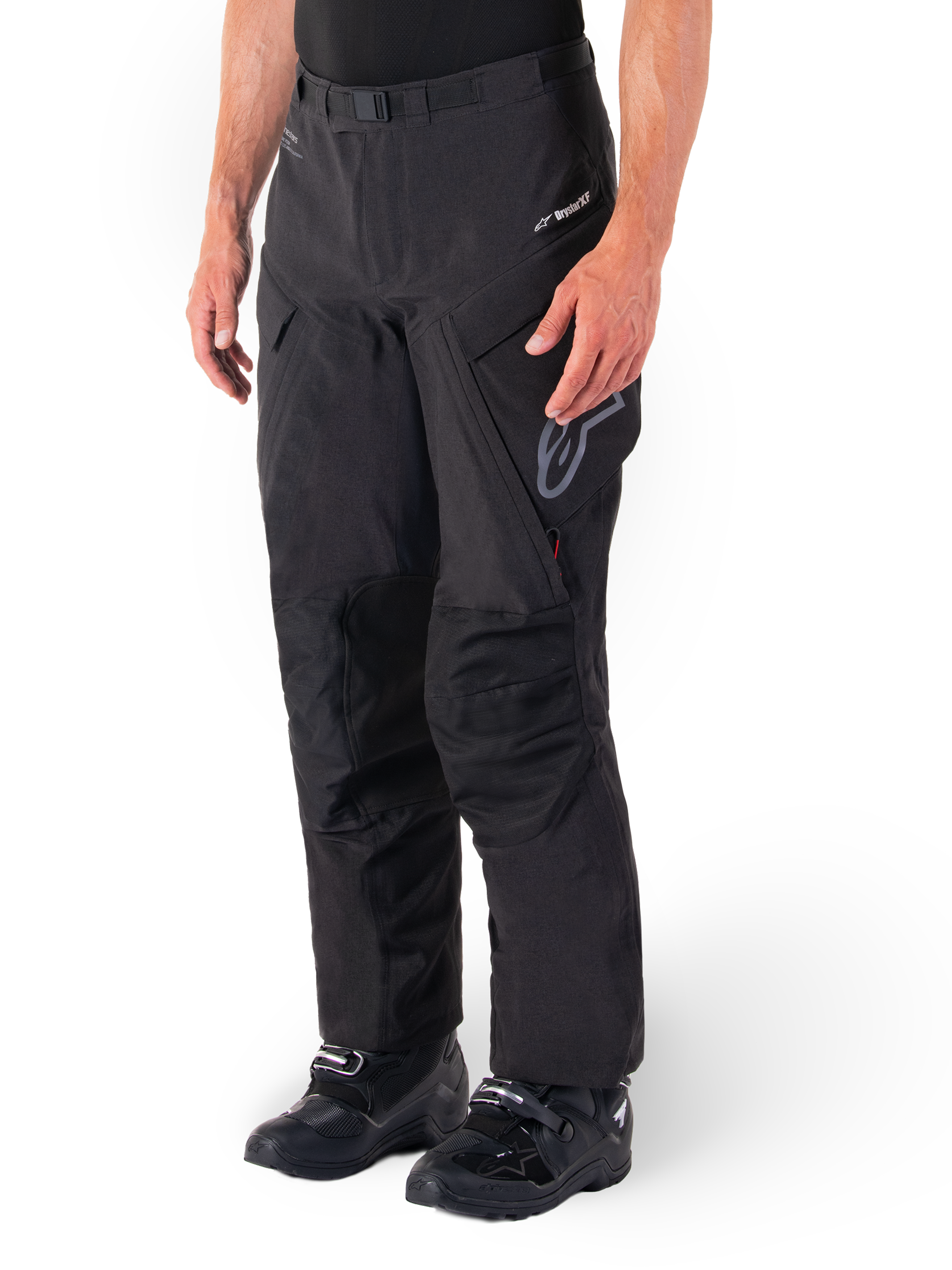 Alpinestars Hyde XT Drystar® Hose, Adventure Touring Motorradhose, Schwarz, getragen mit schwarzen Stiefeln, mit Branding der laminierten Drystar®XF-Membran, verstärkten Knieeinsätzen und Cargo-Taschen mit Reißverschluss.