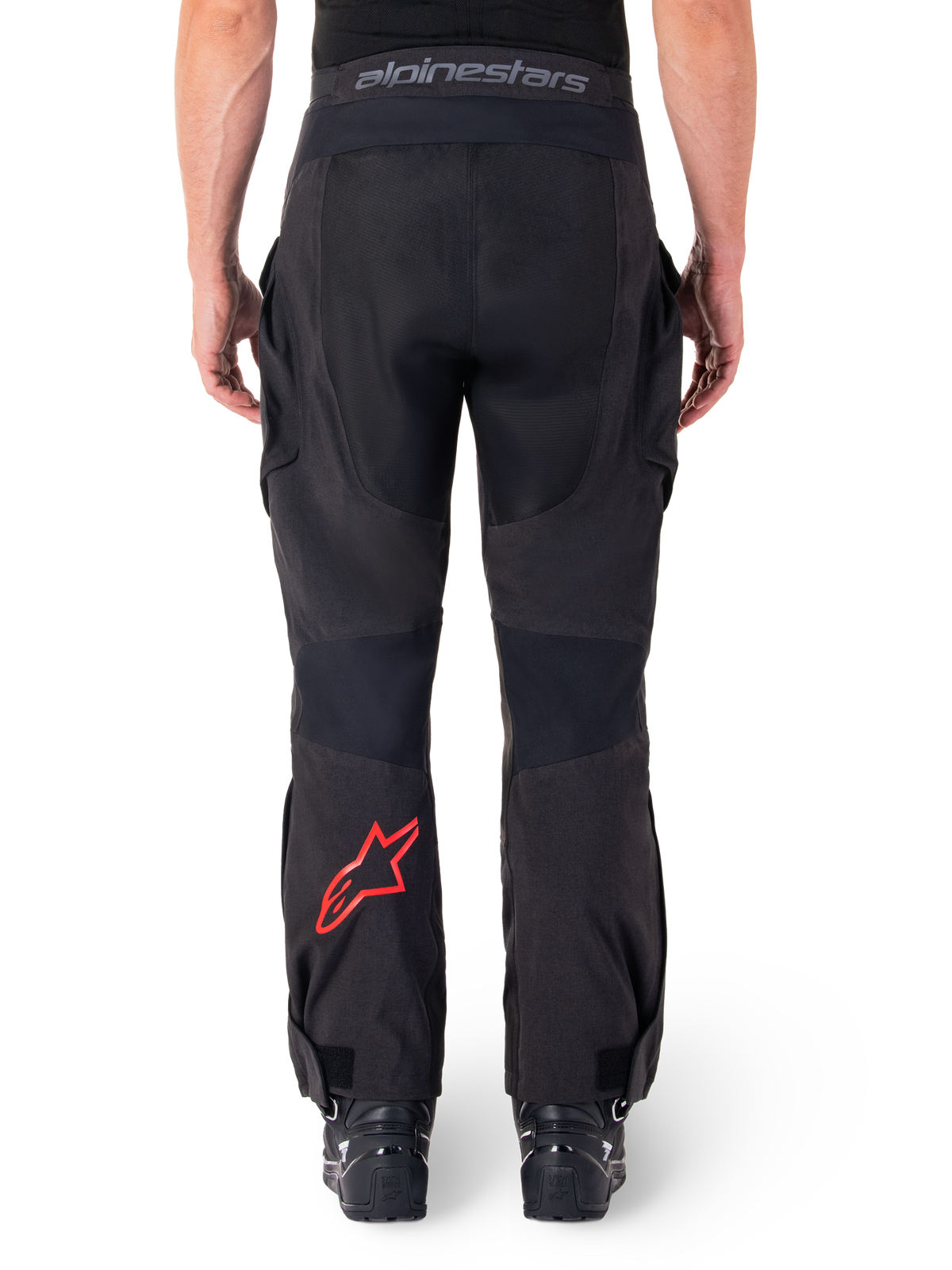 Alpinestars Hyde XT Drystar® Hose, Adventure-Motorradhose, Schwarz mit rotem Stern-Logo am Unterschenkel, Rückansicht, Over-the-Boot-Enduro-Design mit strapazierfähigen Textileinsätzen und Logo-Bund.