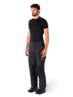 Alpinestars Hyde XT Drystar® Hose, schwarze Adventure-Touring-Motorradhose, getragen von einem Model mit einem schwarzen Kompressionsshirt und schwarzen Stiefeln, technische wasserdichte Konstruktion und Drystar®XF-Branding.