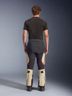 Alpinestars Halo Pro Drystar® XF Laminated Pants, Mastic Black, rear view on a model, black and beige color blocking with orange logos, adventure motorcycle touring pants with durable textile construction and adjustable calf sections