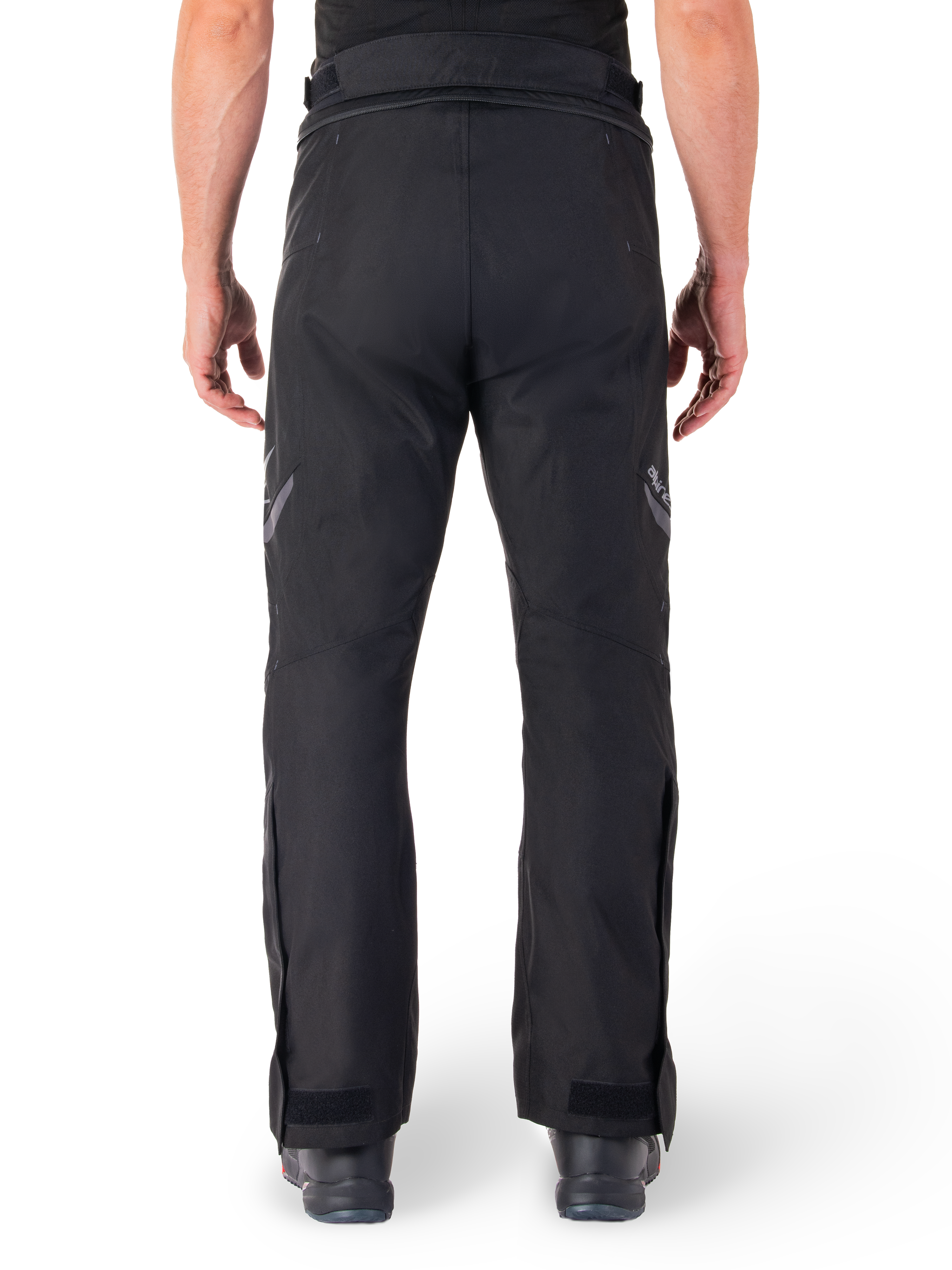 Alpinestars St-1 Waterproof Pants, Motorcycle Touring Pants, Black, back view showing reflective detailing on thighs and adjustable ankle closures, worn with black boots, minimalist design for all-weather road and adventure riding