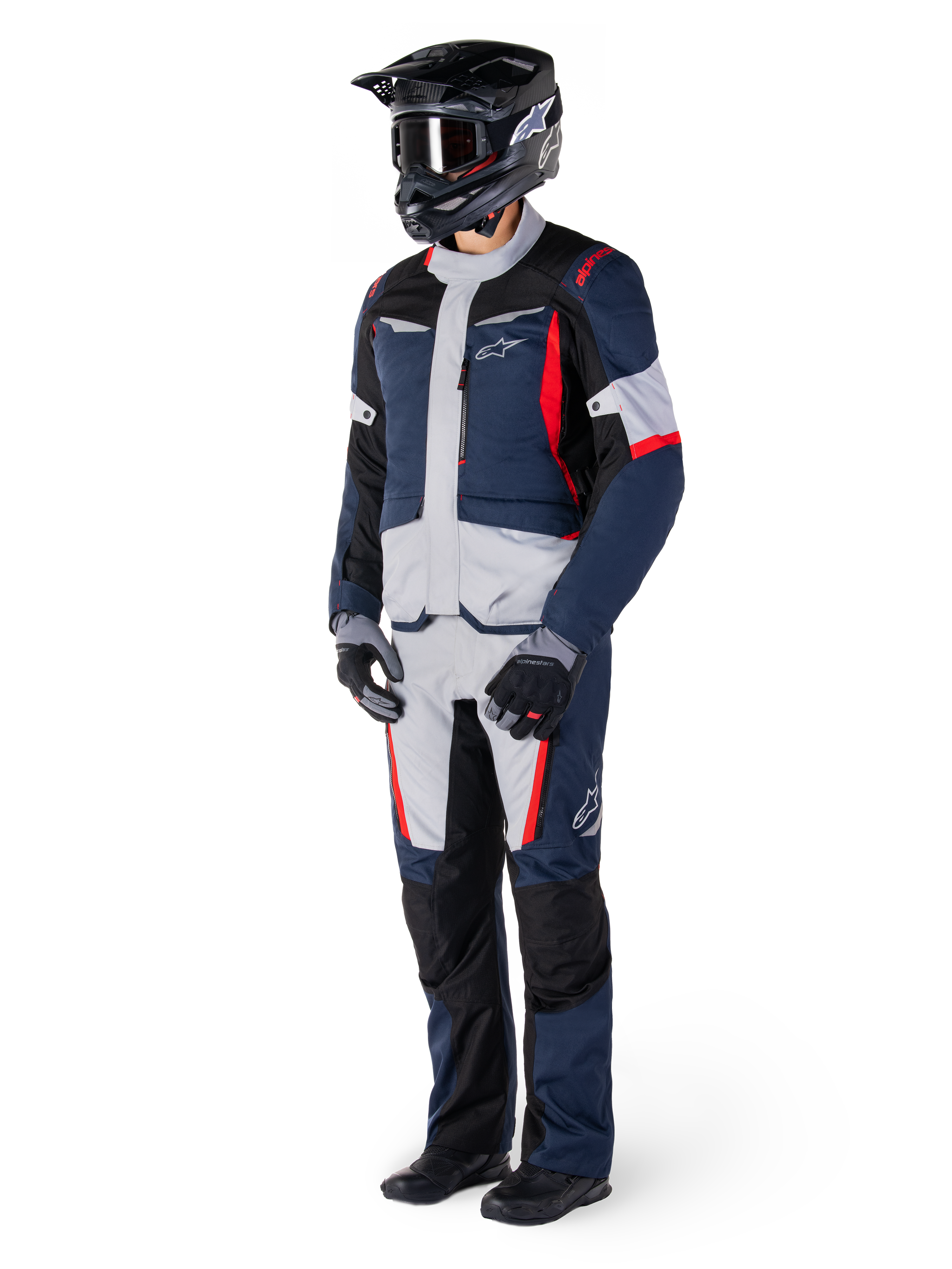 Pantalon imperméable Alpinestars St-1, pantalon Adventure Touring, bleu foncé, noir et rouge vif, porté avec une veste de touring assortie, un casque noir, des gants et des bottes, avec des panneaux gris clair, des accents rouges et le logo Alpinestars, conçu pour la conduite par tous les temps