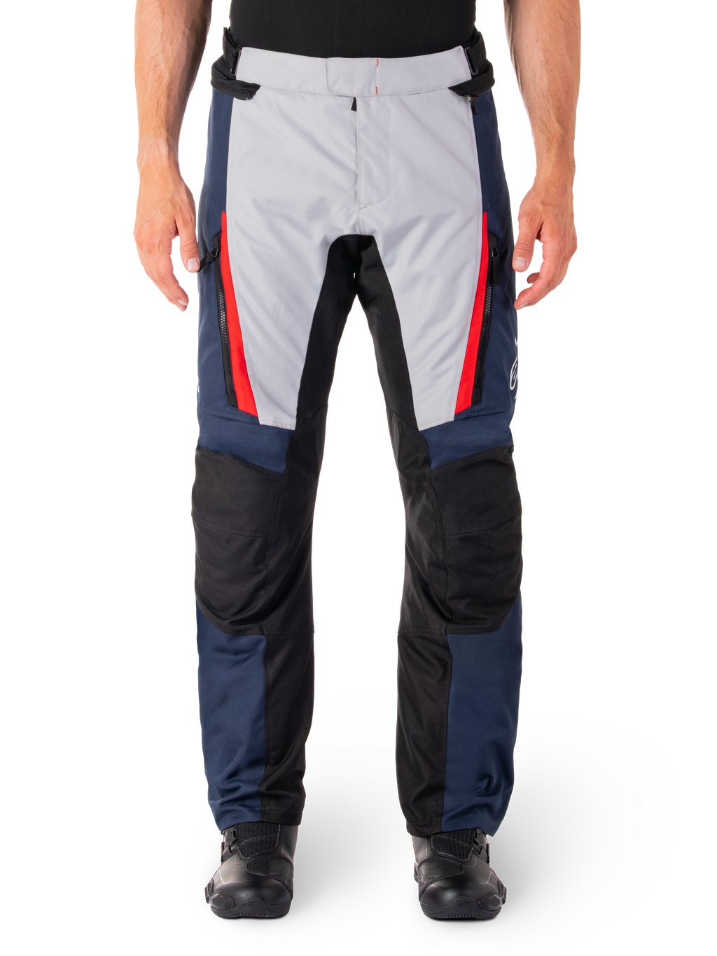 Alpinestars ST-1 Waterproof Pants, pantalon de moto touring, bleu foncé et gris clair avec des accents rouge vif, empiècements renforcés noirs aux genoux, vue de face porté avec des bottes noires, équipement de touring aventure imperméable