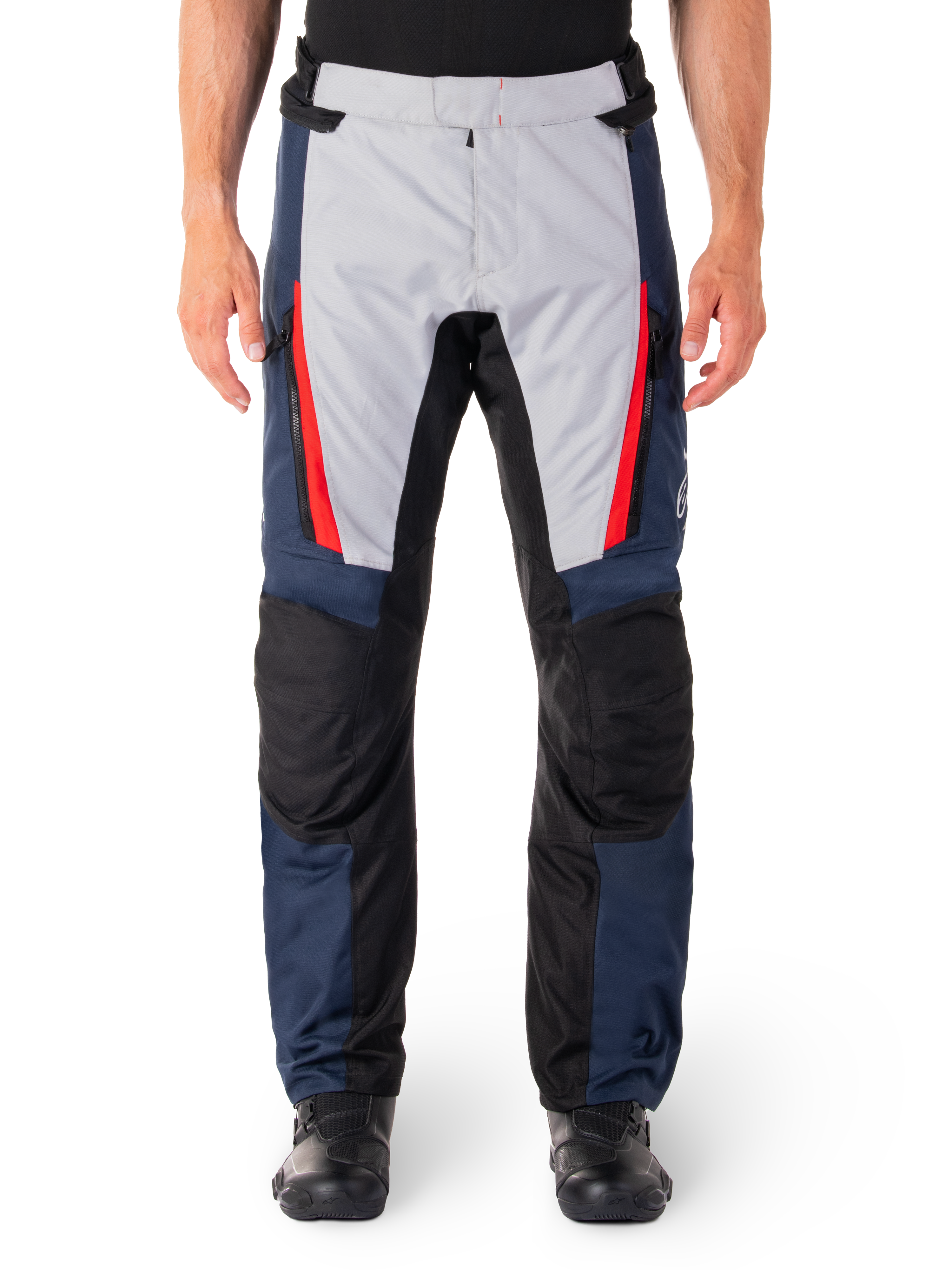 Alpinestars ST-1 Waterproof Pants, pantalon de moto touring, bleu foncé et gris clair avec des accents rouge vif, empiècements renforcés noirs aux genoux, vue de face porté avec des bottes noires, équipement de touring aventure imperméable