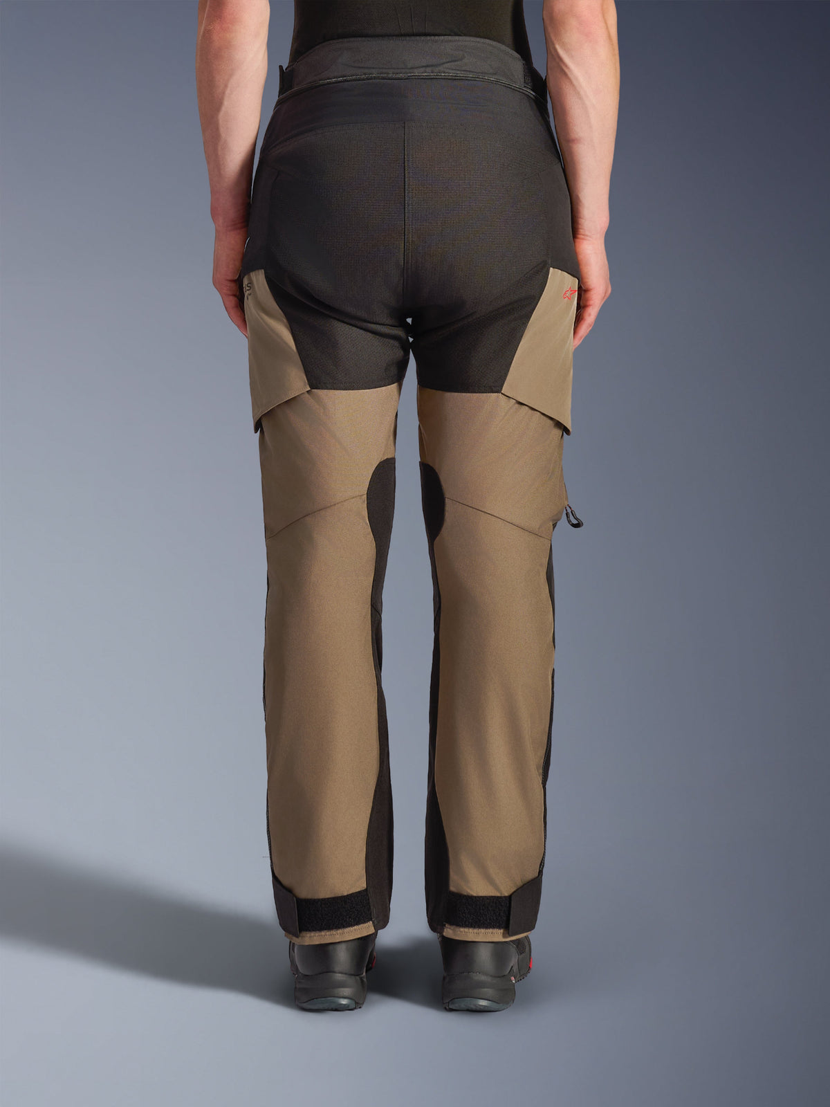 Pantalon Alpinestars Andes V4 Drystar®, pantalon de moto adventure touring, noyer et noir, vue arrière présentant des panneaux d'assise noirs renforcés, un logo rouge et des fermetures réglables aux chevilles.