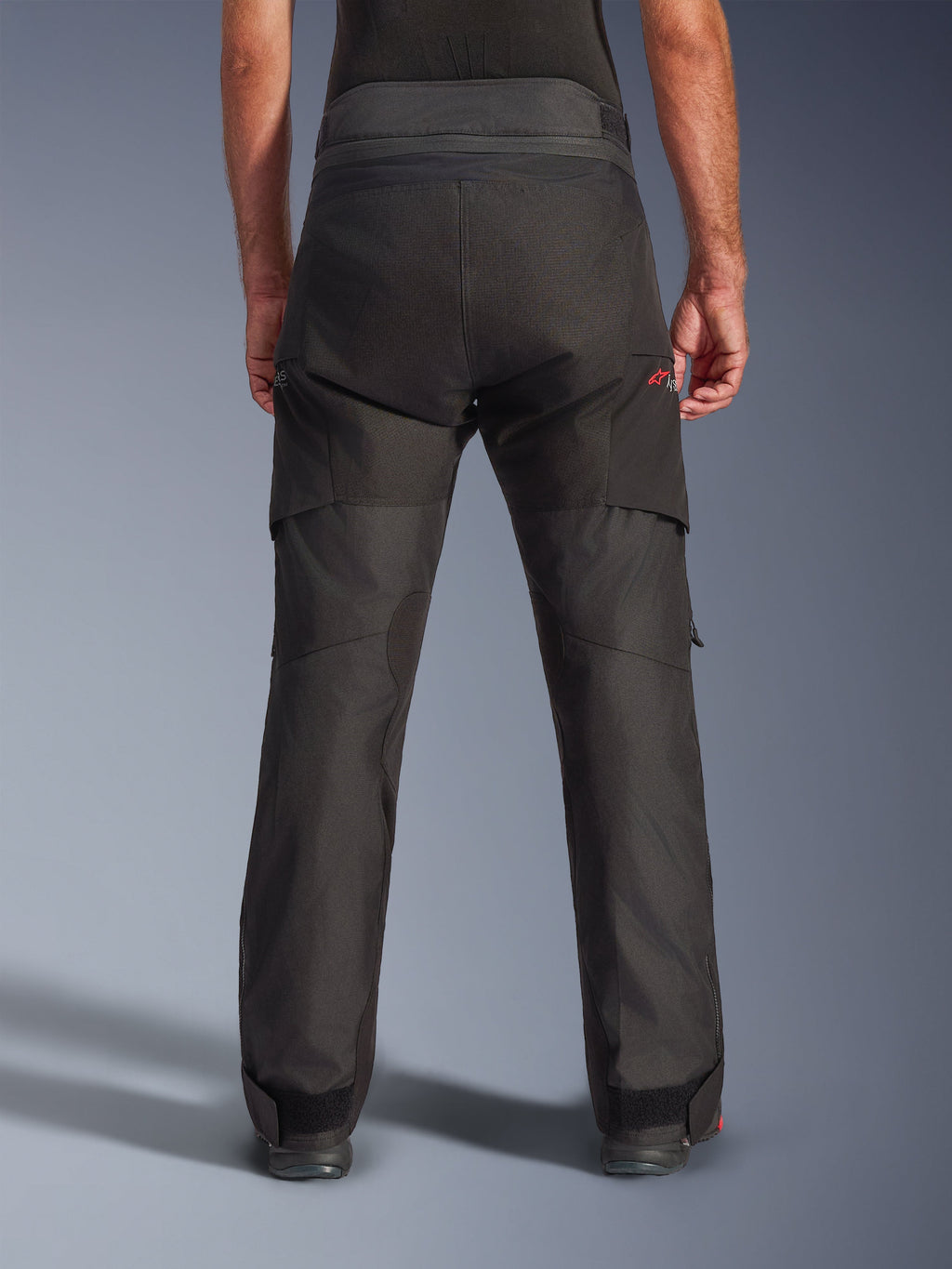Pantalon Alpinestars Andes V4 Drystar®, pantalon de moto en textile, noir, vue arrière montrant les panneaux renforcés et la taille ajustable, équipement de touring aventure avec des accents de logo rouges