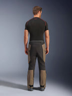 Alpinestars Cusco Drystar® Pants, pantalon de moto aventure, Walnut Black, vue de dos montrant des empiècements marron et noirs, construction en ripstop durable, porté avec un haut de couche de base noir