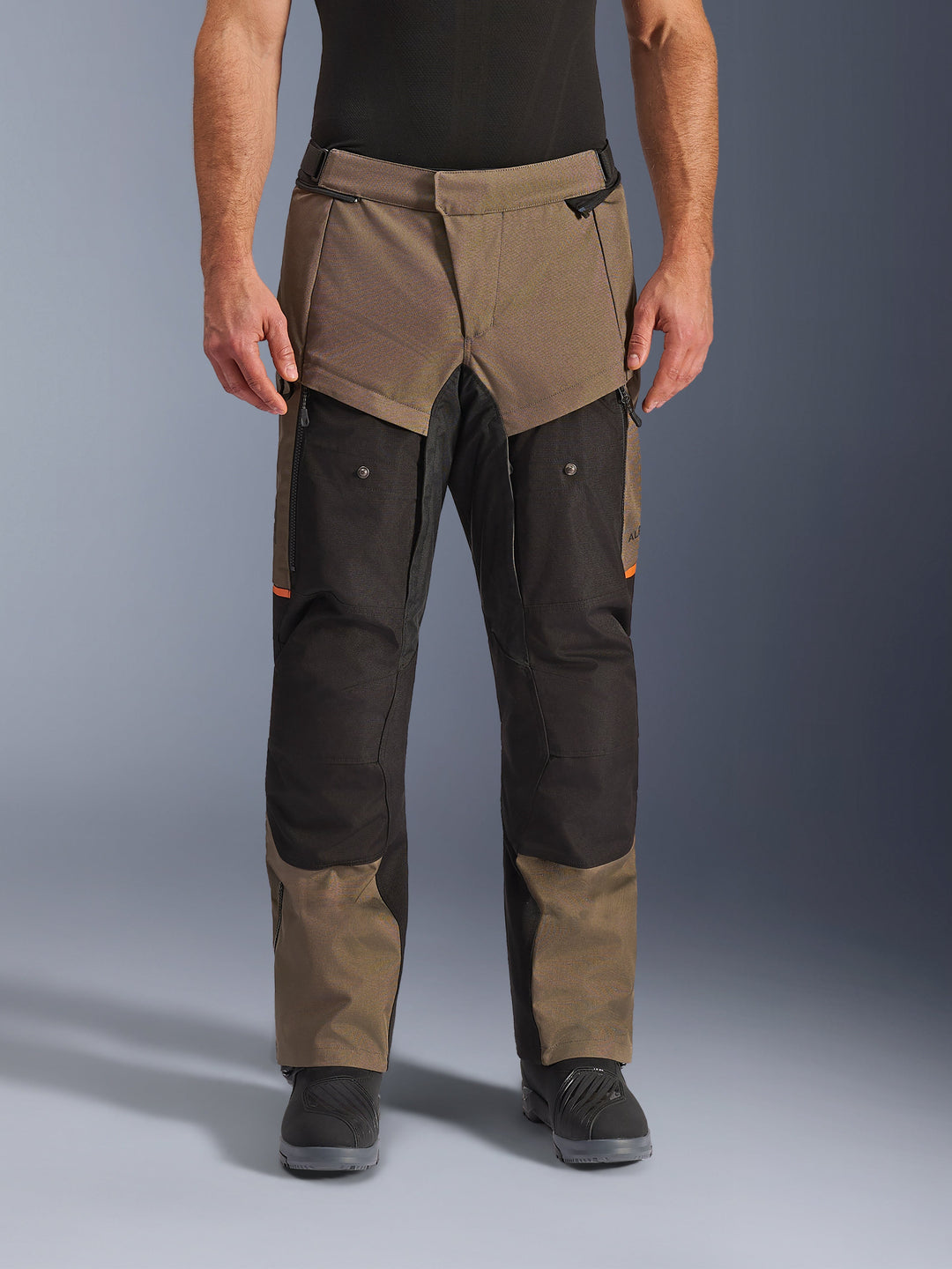 Alpinestars Cusco Drystar® Pants, pantalon de moto Adventure Touring, noyer et noir avec accents orange, vue de face sur modèle, construction en textile technique, poches cargo et fermetures éclair de ventilation, porté avec des bottes de moto noires