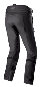 Pantalon Alpinestars Bogotá Pro Drystar® 3 Seasons, pantalon de moto aventure touring noir vu de l'arrière, présentant un logo sur la ceinture, des sangles de jambe réglables et une construction en textile technique avec des panneaux renforcés.