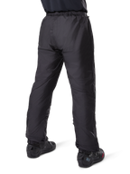 Alpinestars Bogotá Pro Drystar® 3 Seasons Pants, pantalon de moto touring aventure noir, vue arrière de la doublure imperméable Drystar® portée comme sur-pantalon, associé à des bottes de moto noires, construction technique légère pour une protection contre les intempéries multi-saisons
