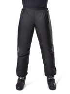 Pantalon Alpinestars Bogotá Pro Drystar 3 Saisons, pantalon de moto imperméable, noir, tissu technique léger avec empiècements réfléchissants aux genoux, porté en sur-pantalon avec des bottes de moto noires, conçu pour la protection contre les intempéries en touring d'aventure