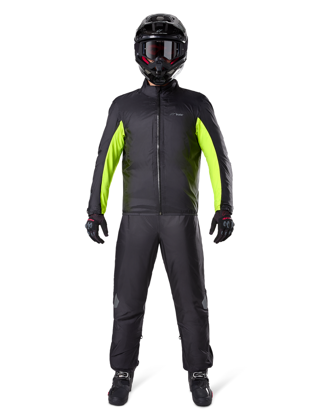 Pantalon Alpinestars Bogota Pro Drystar 3 Seasons, noir, porté par un motard avec une tenue d'aventure complète comprenant une veste imperméable noire et jaune fluo, un casque noir et des bottes de moto, conçu pour la performance de touring par tous les temps.