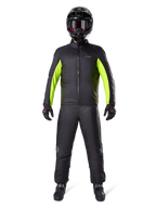 Pantalon Alpinestars Bogota Pro Drystar 3 Seasons, noir, porté par un motard avec une tenue d'aventure complète comprenant une veste imperméable noire et jaune fluo, un casque noir et des bottes de moto, conçu pour la performance de touring par tous les temps.