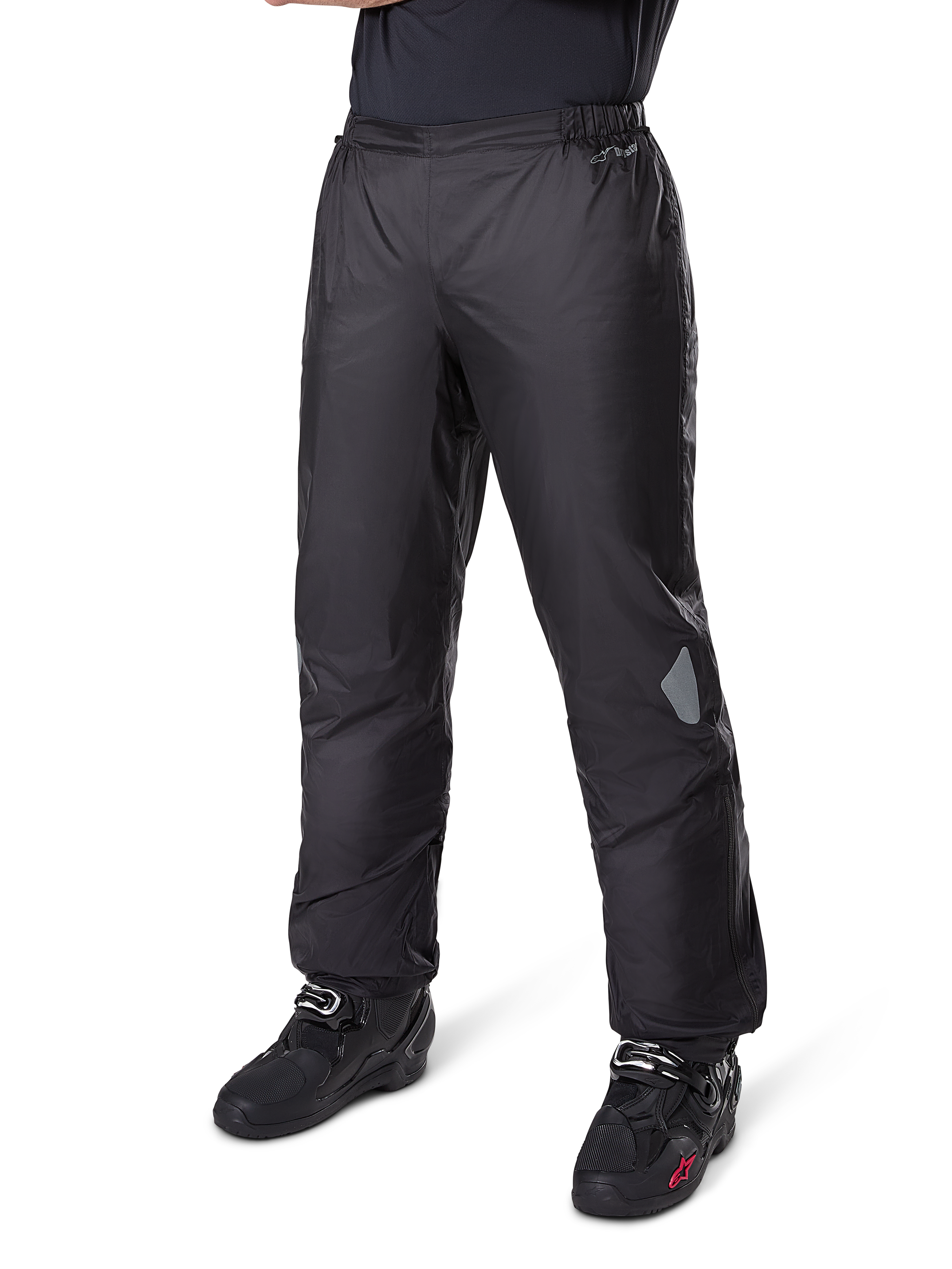 Pantalon Alpinestars Bogotá Pro Drystar® 3 Seasons, pantalon de moto adventure touring, noir, porté avec des bottes de moto noires, avec empiècements réfléchissants aux genoux et logo Drystar, conception textile imperméable légère pour une conduite toutes saisons