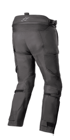 Alpinestars Bogotá Pro Drystar® 4 Saisons - Court, pantalon de moto de touring d'aventure, noir, vue arrière montrant la taille haute avec logo, panneau extensible en accordéon, sangles de réglage aux mollets et construction textile technique.