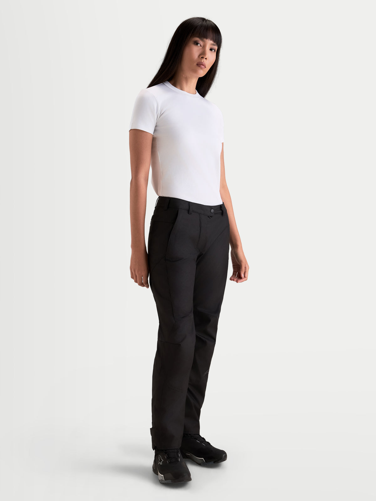 Alpinestars Stella C-1 Waterproof broek, dames urban motorbroek in zwart, rechte textielconstructie gedragen door model met wit t-shirt, kleding voor koud weer