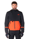 Alpinestars Mootant Waterproof Parka, veste de moto modulaire en Spicy Orange et noir, portée par un mannequin avec des gants assortis, présente un design à capuche avec des empiècements bicolores, une fermeture éclair frontale et des poignets réglables, vêtement de moto urbain contemporain