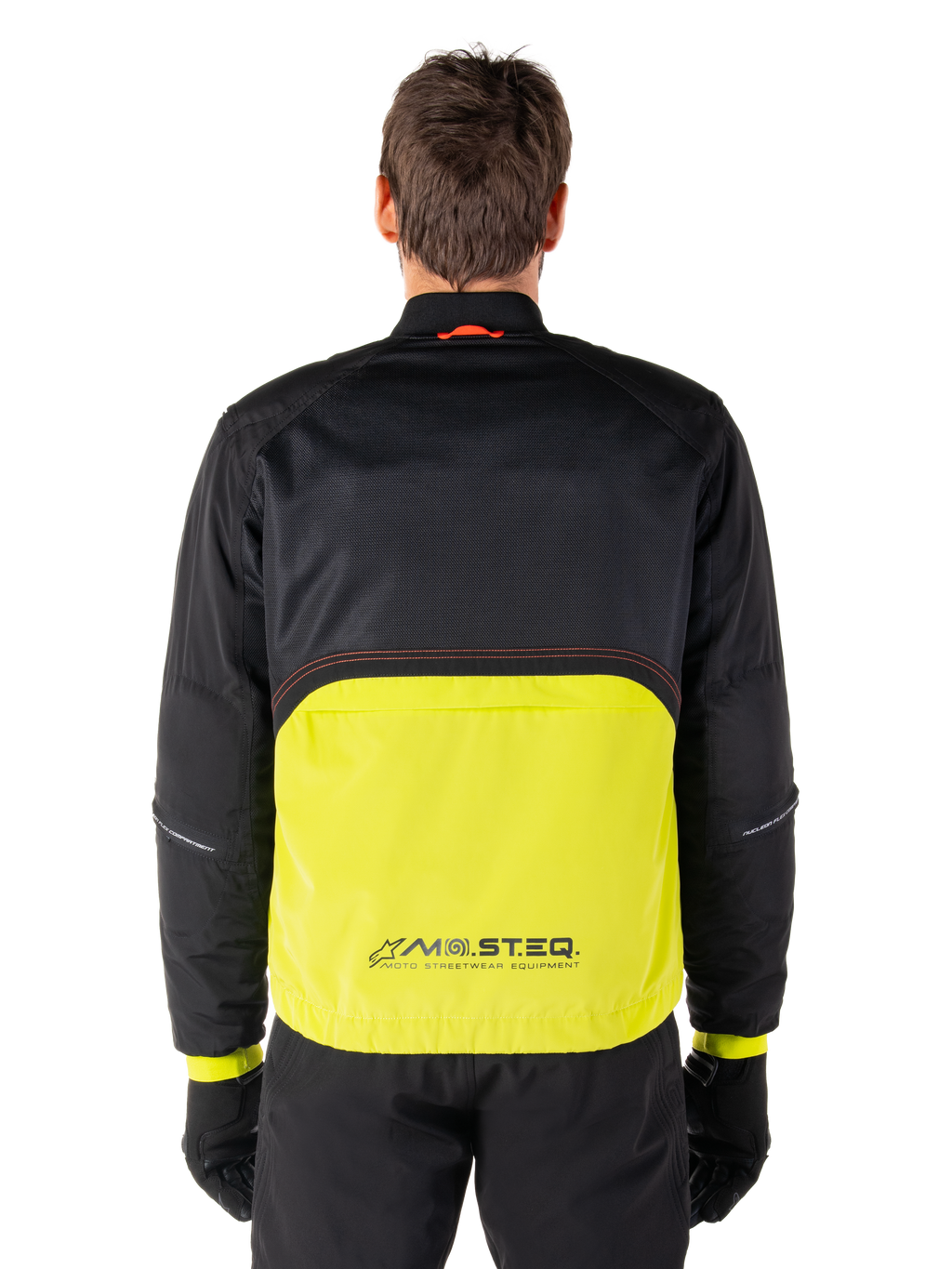 Alpinestars Mootant Waterproof Parka, motorjas, Lime Punch en zwart, achteraanzicht met zwart mesh bovenstuk voor ventilatie en limegroen onderstuk met MO.ST.EQ.-logo, gedragen met zwarte broek en handschoenen