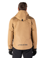 Alpinestars Morush Waterproof Parka, Utility Brown, achteraanzicht, voorzien van een capuchon en MO.ST.EQ.-branding op de onderrug, gecombineerd met een zwarte broek en handschoenen, moderne op streetwear geïnspireerde motorkleding