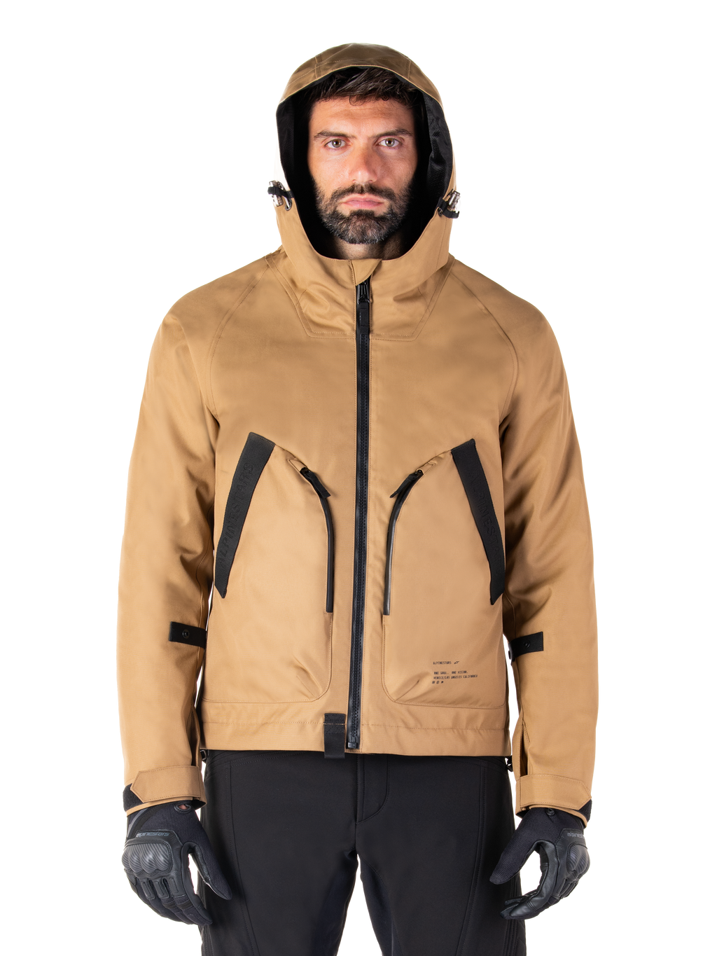 Alpinestars Morush Waterproof Parka, motorjas, Utility Brown, streetwear-geïnspireerd ontwerp met capuchon en grote voorzakken met zwarte accenten, gedragen met zwarte motorhandschoenen en broek, urban contemporary motorkleding