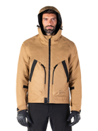 Alpinestars Morush Waterproof Parka, motorjas, Utility Brown, streetwear-geïnspireerd ontwerp met capuchon en grote voorzakken met zwarte accenten, gedragen met zwarte motorhandschoenen en broek, urban contemporary motorkleding
