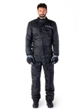 Alpinestars Hurricane Rain V2 Suit, volledig motorregenpak in het zwart, waterdichte beschermende kleding met hoge kraag en stormsluiting aan de voorzijde, voorzien van een wit logo op de borst, gedragen met zwart-grijze handschoenen en laarzen