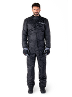 Alpinestars Hurricane Rain V2 Suit, volledig motorregenpak in het zwart, waterdichte beschermende kleding met hoge kraag en stormsluiting aan de voorzijde, voorzien van een wit logo op de borst, gedragen met zwart-grijze handschoenen en laarzen
