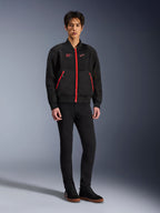 Veste Alpinestars Flight Air en Noir Rouge Vif, veste de moto urbaine de style bomber avec panneaux en maille 3D et fermetures éclair rouge vif, portée par un mannequin avec un pantalon slim noir et des baskets noires, équipement de moto contemporain d'inspiration streetwear
