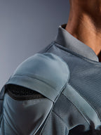 Nahaufnahme der Alpinestars Flight Air Jacke in Storm Gray, die die externe Schulterprotektorentasche mit sichtbarem Wabenprotektor, 3D-Mesh-Belüftungseinsätze und den gerippten Kragen für technisches urbanes Motorradfahren hervorhebt