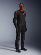 Modèle portant la veste Alpinestars Viper Air V4 en noir et rouge fluo, dotée de panneaux en mesh et de logos étoilés rouges sur la poitrine et l'épaule, accompagnée d'un pantalon de moto, de gants et de chaussures noirs assortis, ensemble d'équipement de route professionnel